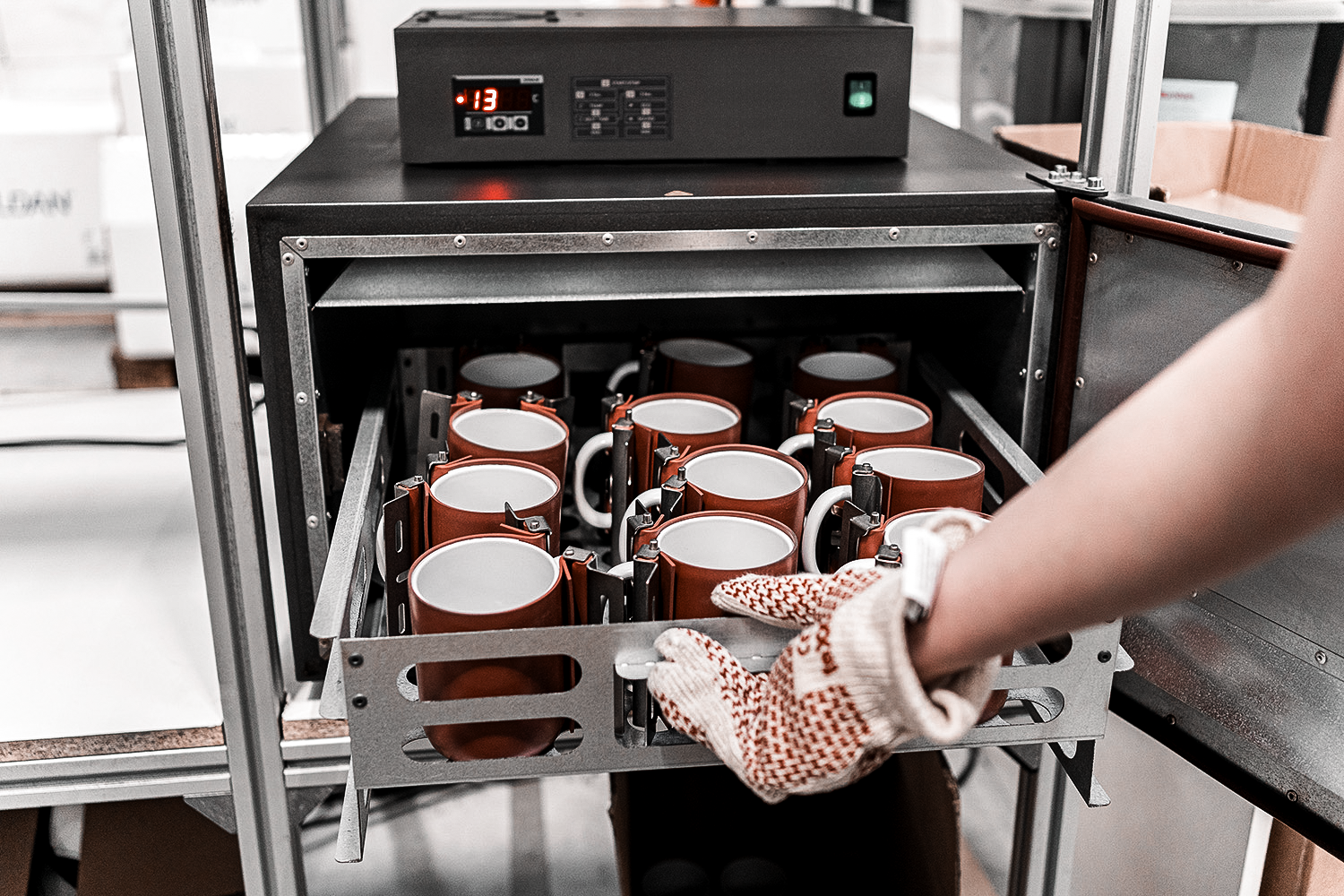 Sublimation printing process – heat press oven with multiple mugs being cured for full-color print application